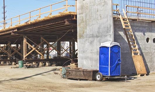 a lineup of sanitized portable restrooms on a busy job site